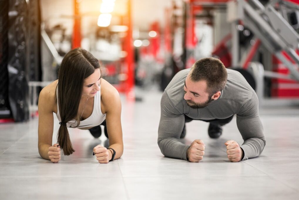 Un homme et une femme exécutent l'exercice de planche conçu pour tous les groupes musculaires
